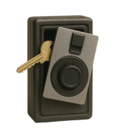 A small, rectangular safe with a combination dial and a gold key inserted into the side, photographed against a plain white background.