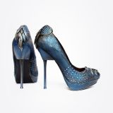 A pair of high-heeled shoes in metallic blue, decorated with small studs and featuring layered, scale-like accents on the heels. The shoes have a fantasy-inspired, ornate design.