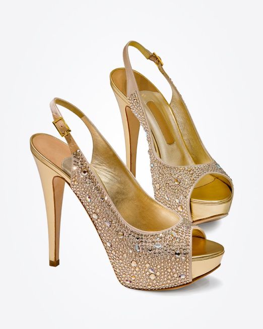 A pair of gold high-heeled slingback shoes with open toes, platform soles, and sparkling rhinestone embellishments on the front and sides, displayed against a plain white background.